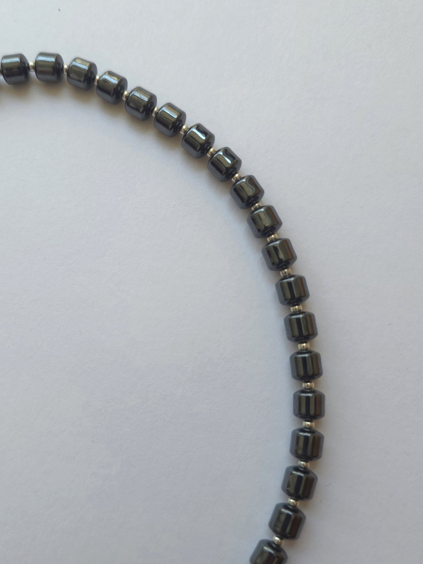 Close-up of polished hematite column beads with silver Japanese Miyuki spacers