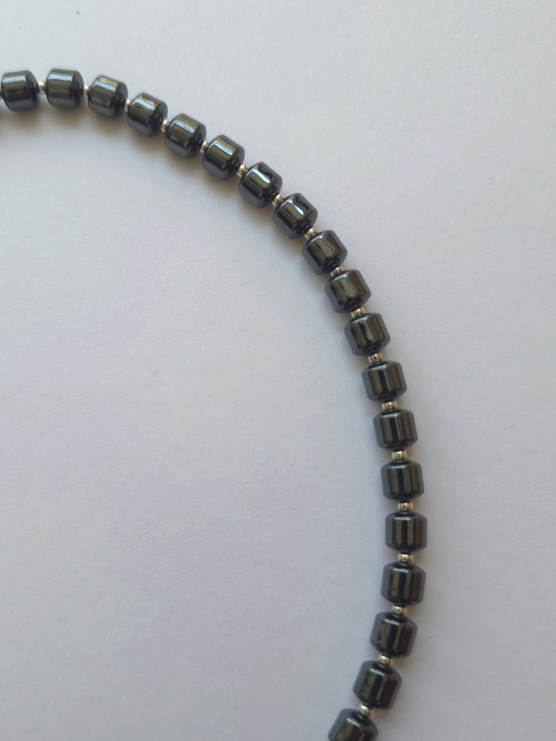 Close-up of polished hematite column beads with silver Japanese Miyuki spacers