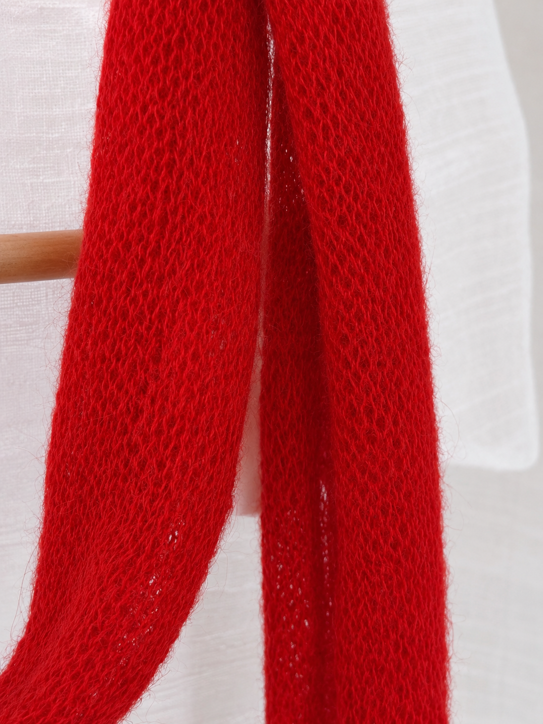 Macro detail of the open knit texture of the Ruby Red kid mohair scarf.
