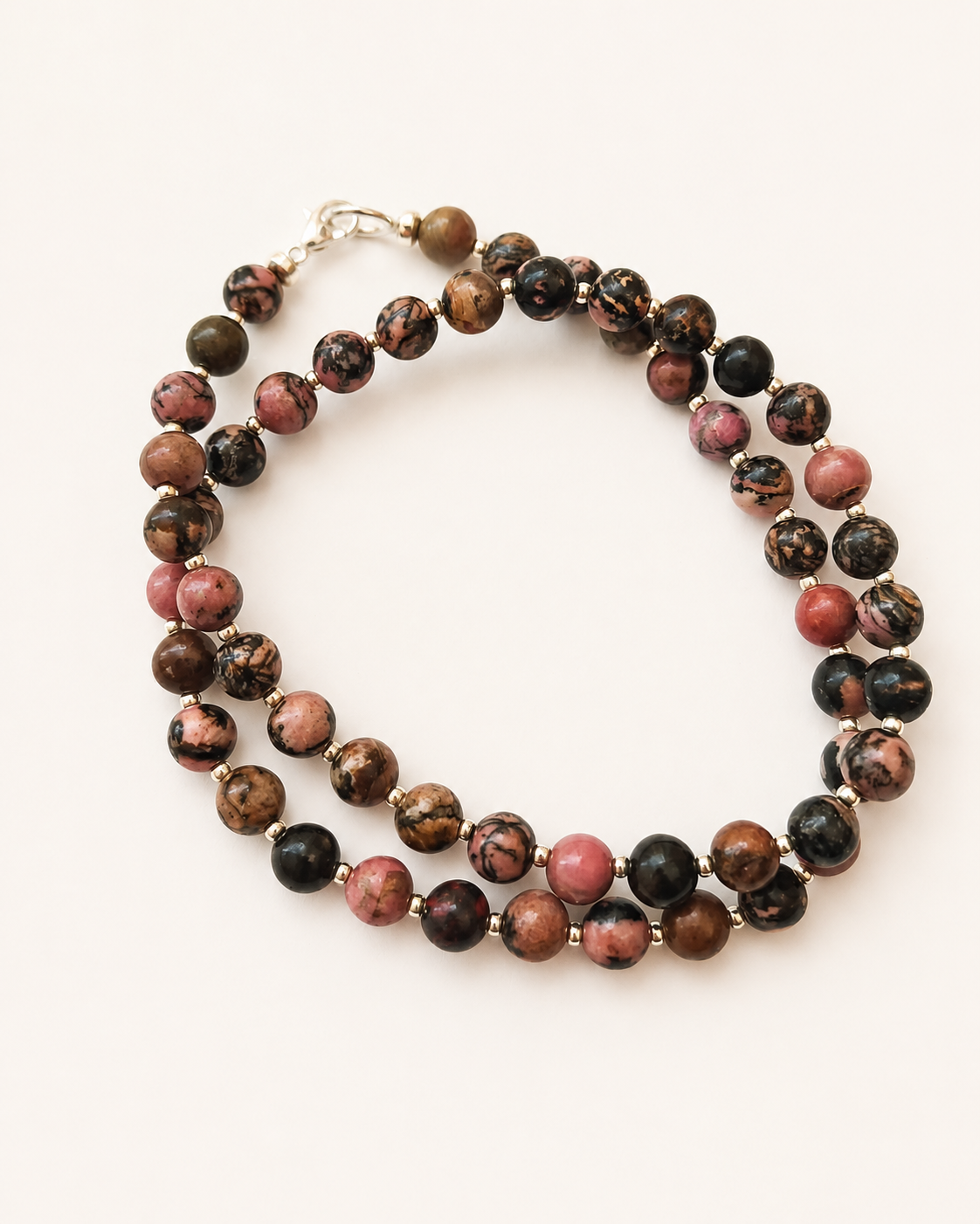 Coiled rhodonite necklace displaying varied natural patterns and silver-coloured accents
