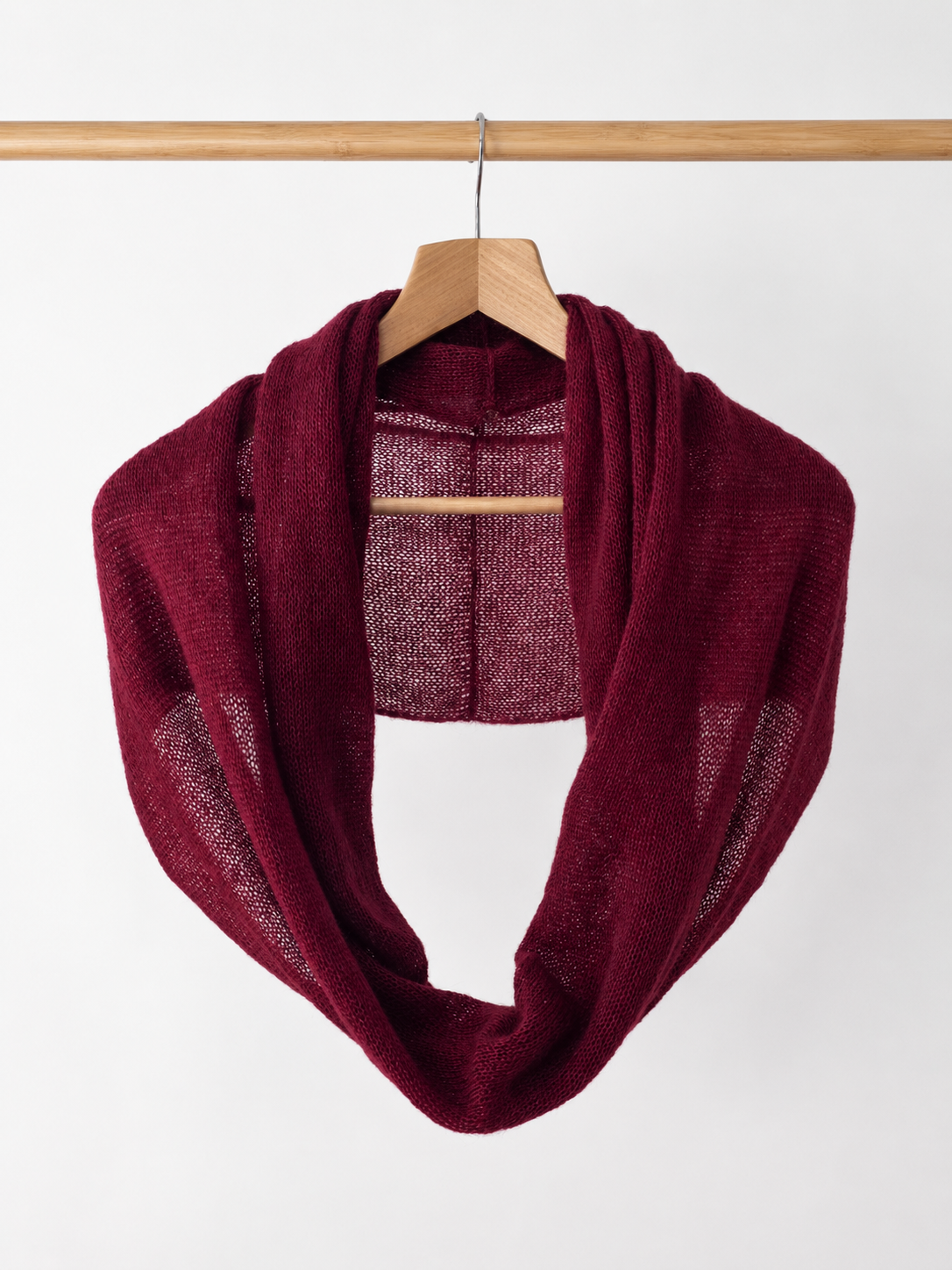 Soft Burgundy kid mohair infinity scarf hanging on a wooden hanger.