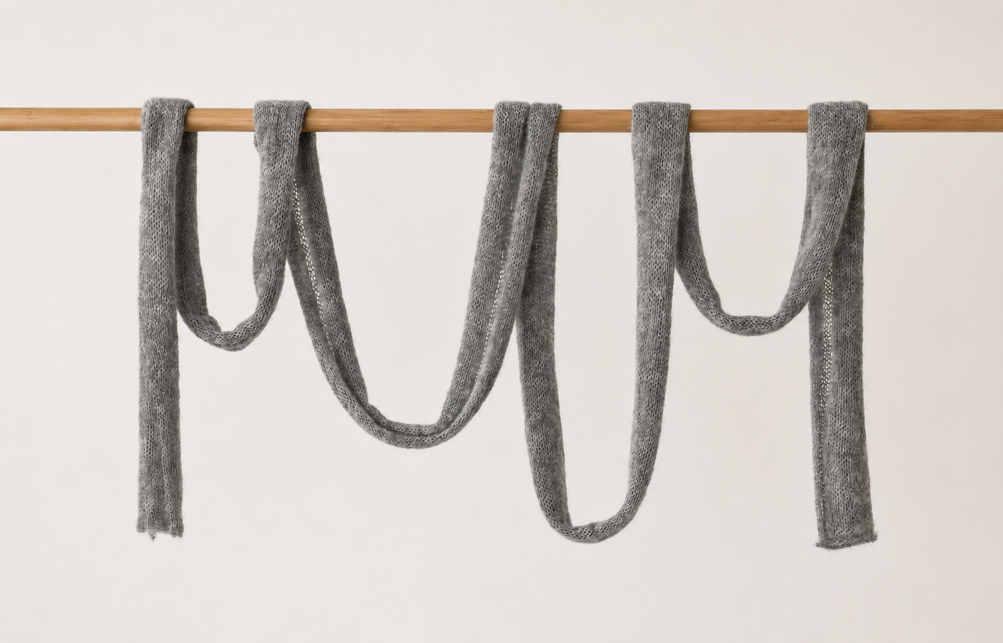 Full-length handmade cloud grey skinny mohair scarf displaying its elegant silhouette.