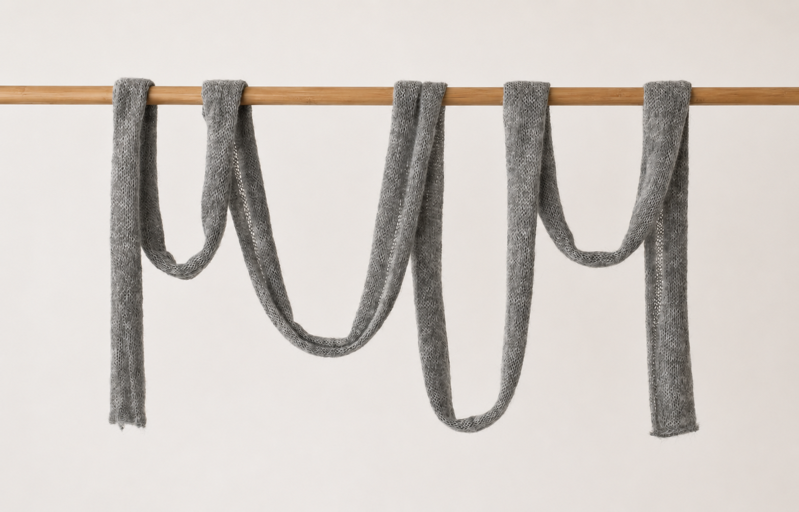 Full-length handmade cloud grey skinny mohair scarf displaying its elegant silhouette.