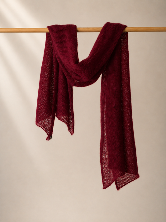 Bordeaux silk mohair shawl draped over a wooden rail in elegant soft folds.