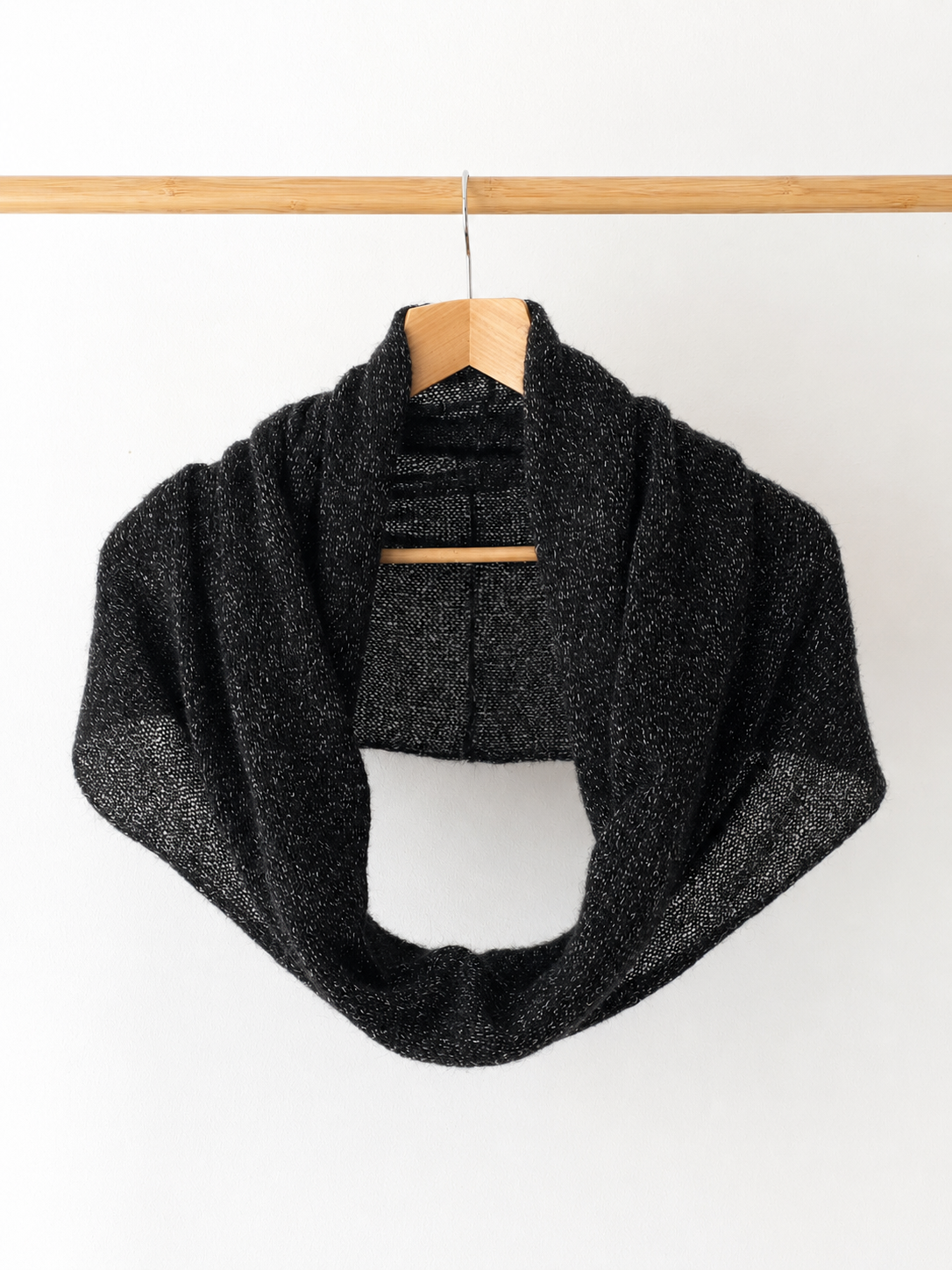 Black mohair infinity loop scarf with silver sparkle hanging on a wooden hanger