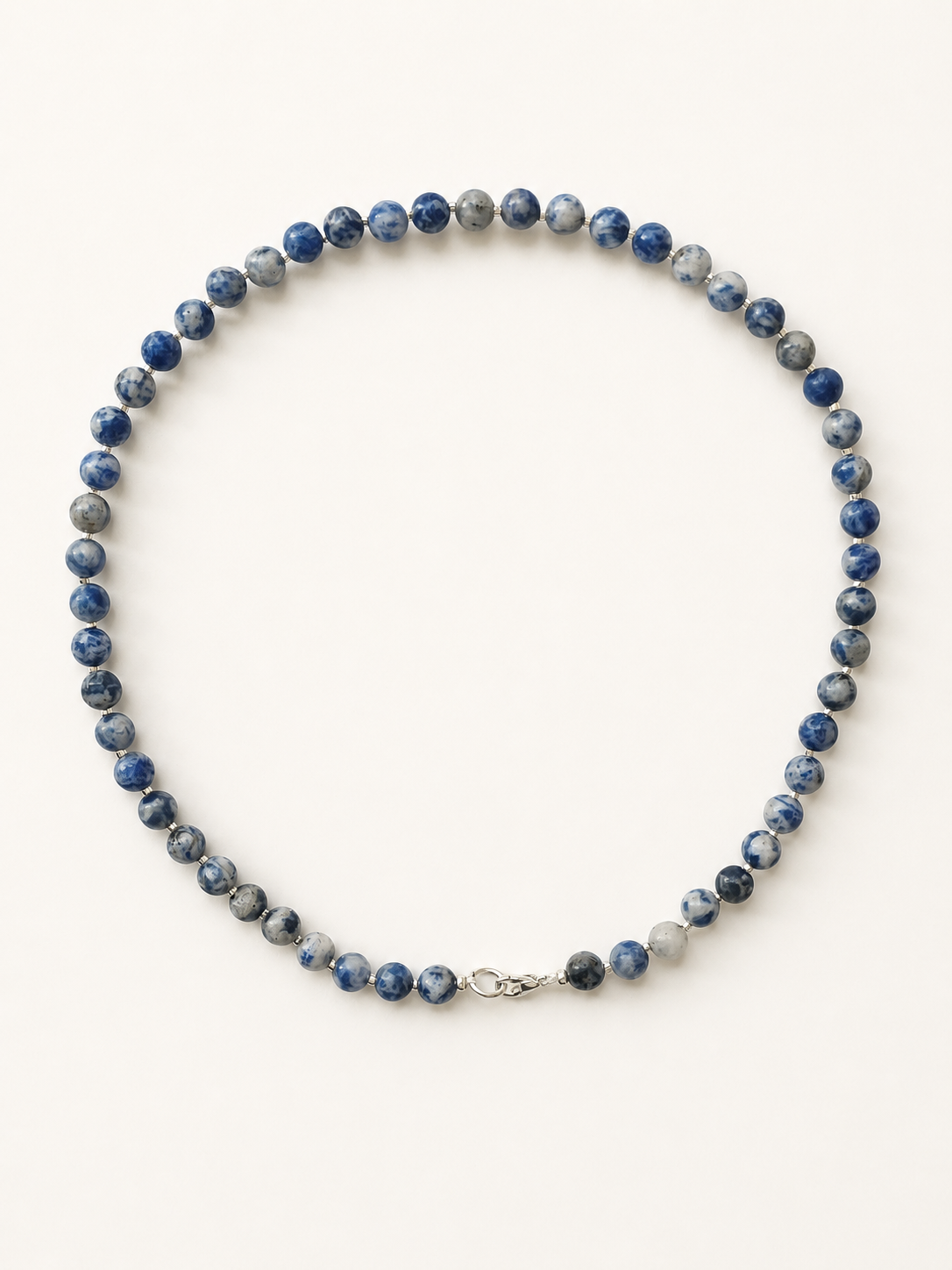 Sodalite necklace with 6mm blue marbled beads and silver accents on a warm ivory background