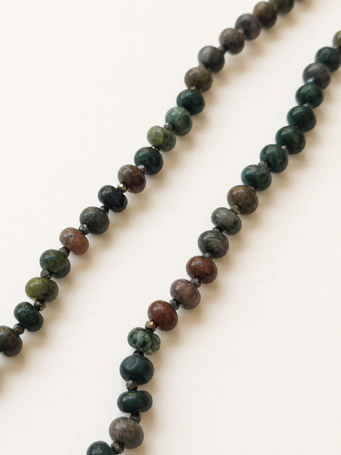 Detailed view of Indian agate gemstone beads separated by small faceted pyrite accents