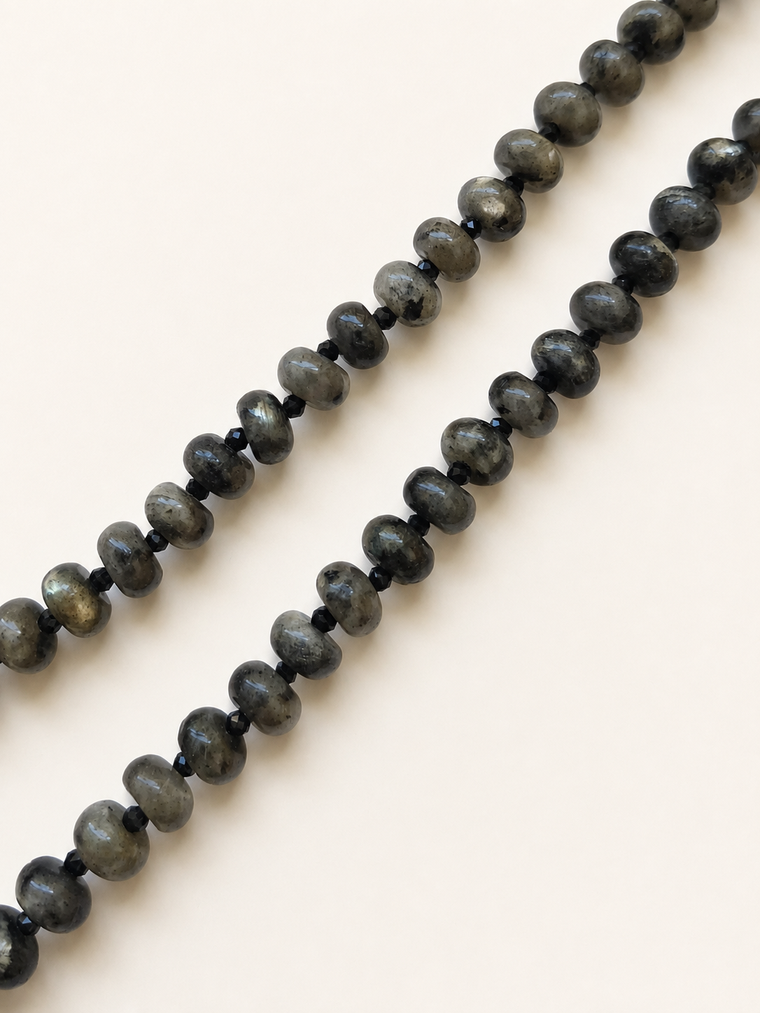 Detailed view of naturally patterned labradorite rondelles and faceted black spinel beads