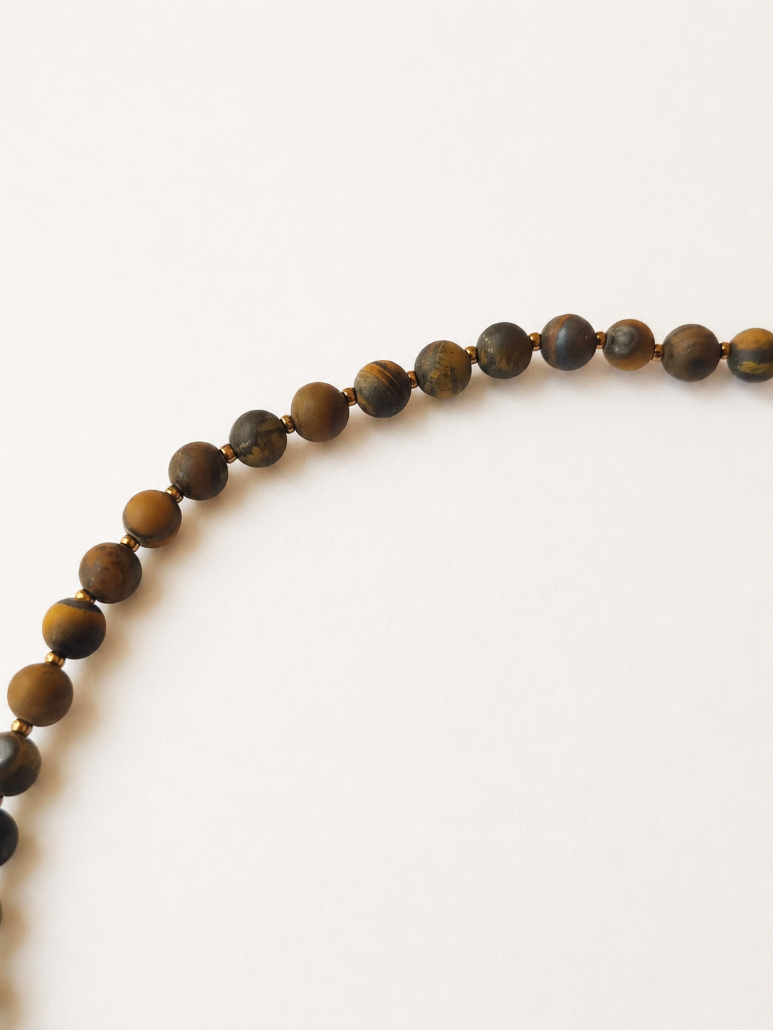 Detailed view of 6mm matte tiger eye gemstone beads and fine gold-colour spacers