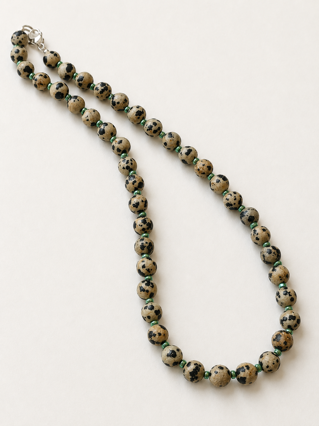 Full 42cm Dalmatian jasper necklace arranged lengthwise to show the spotted gemstone pattern