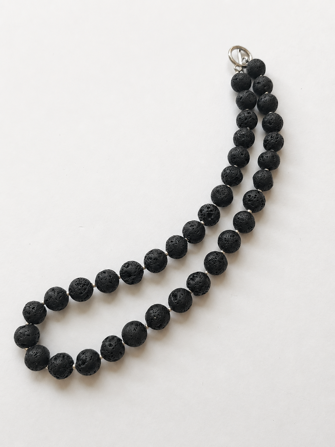 Full-length black lava stone necklace showing silver accents and stainless steel toggle clasp