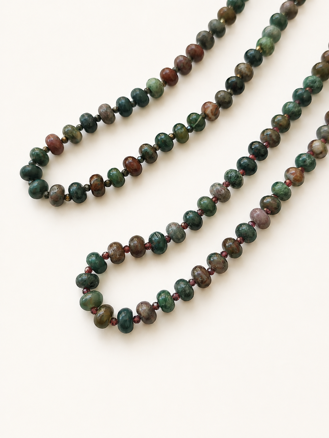 Close-up comparison of Indian agate beads with burgundy glass and dark pyrite spacers