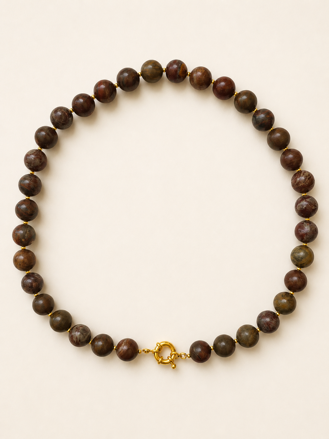 Earth-toned agate necklace with 10mm round gemstone beads and golden details on a warm ivory background