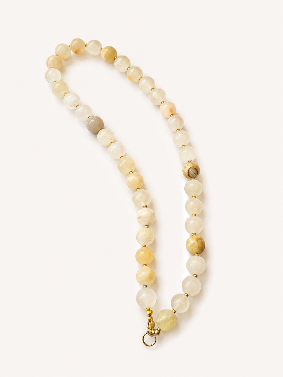 Full-length cream yellow jadeite necklace showing varied natural beads and golden clasp