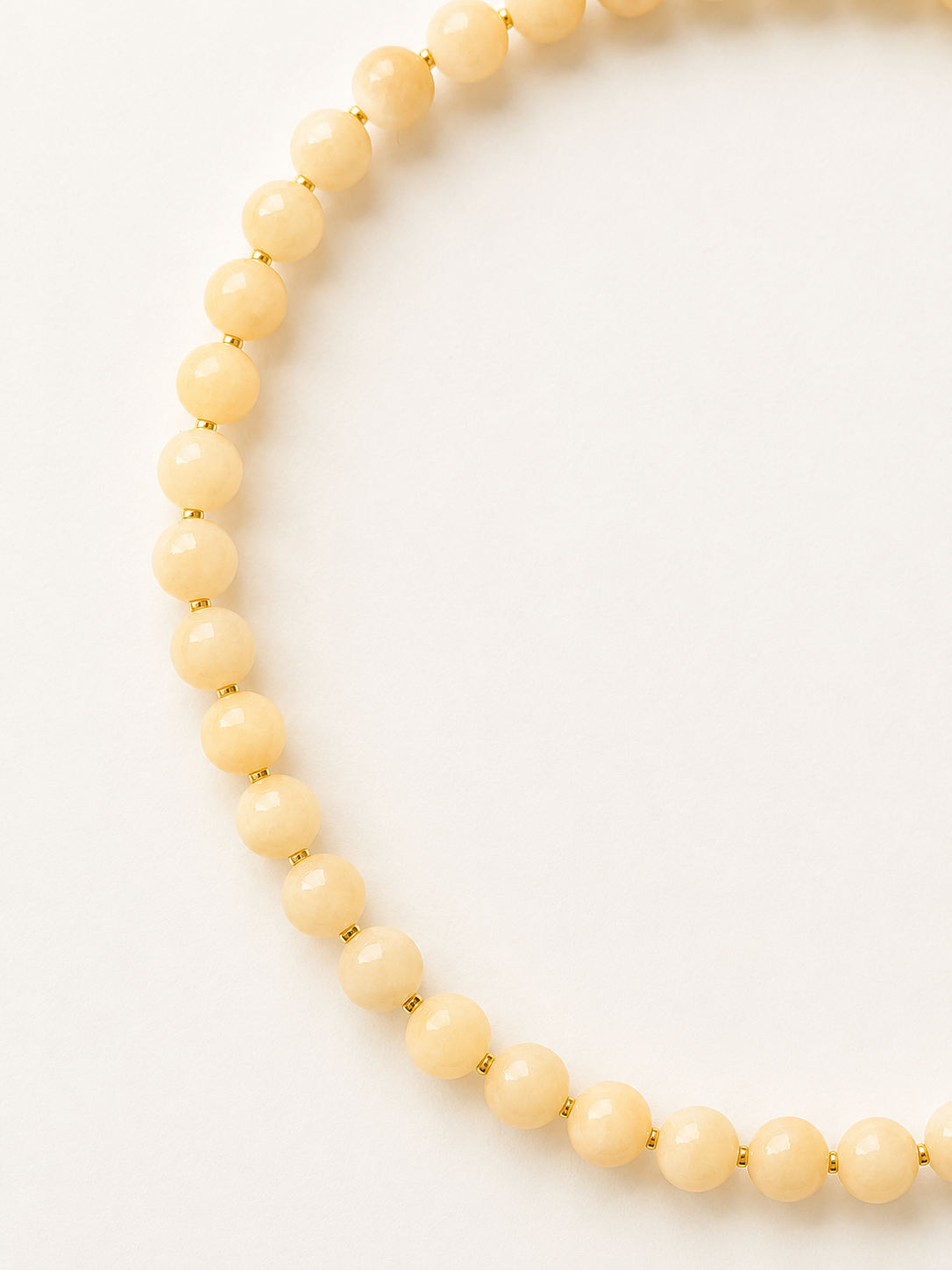 Detailed view of 6mm peach jadeite beads and fine gold accents