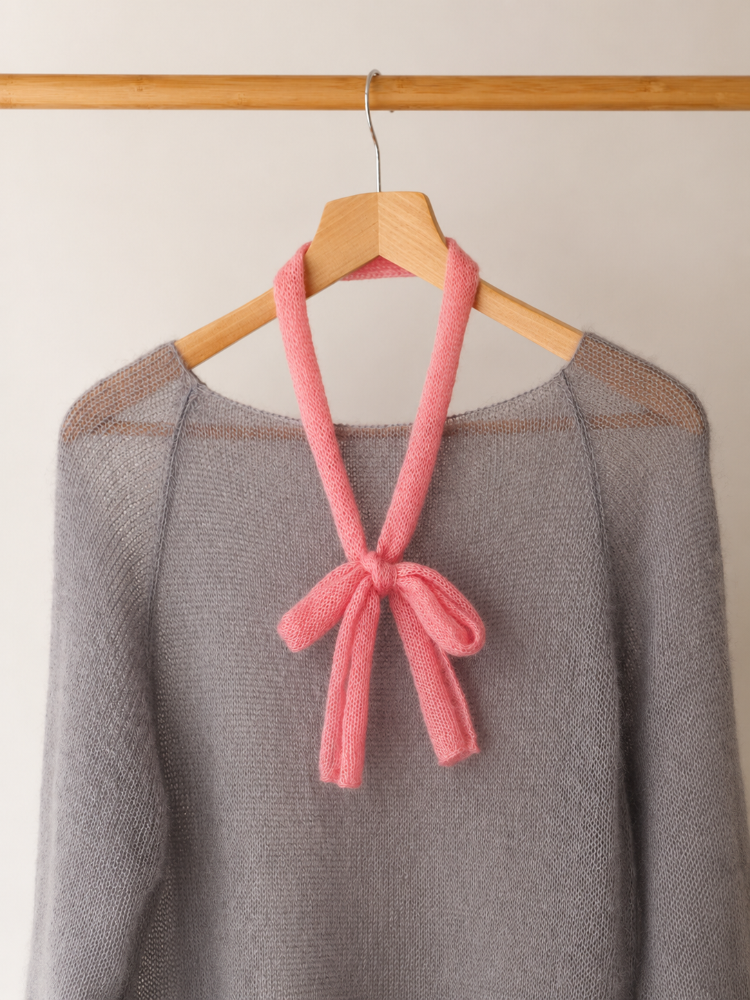 Blush Pink mini scarf styled in a bow over knitwear