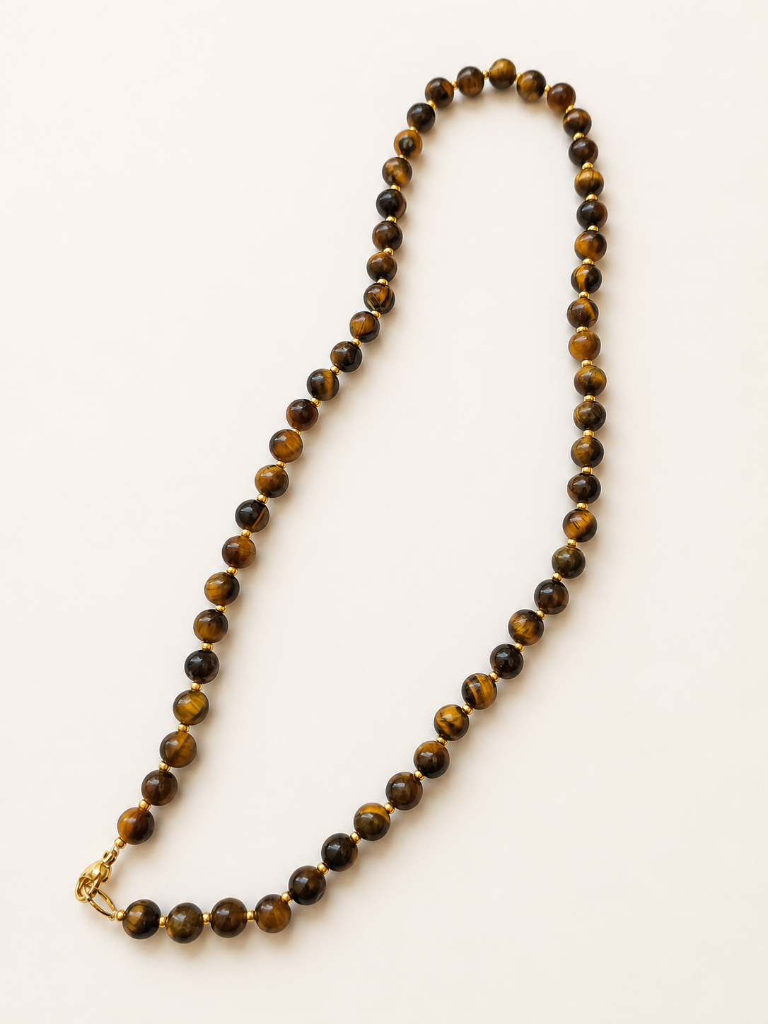 Full-length arrangement of a 44cm tiger eye necklace with polished beads and gold accents