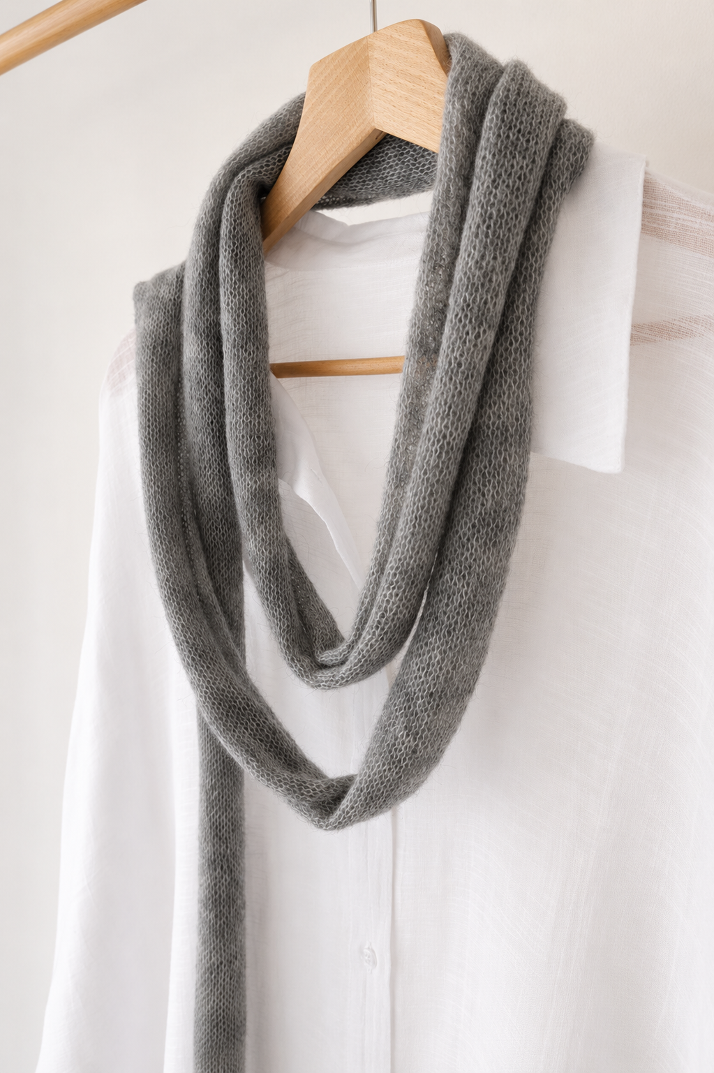 45-degree view of extra-long grey kid mohair scarf on a white linen shirt.