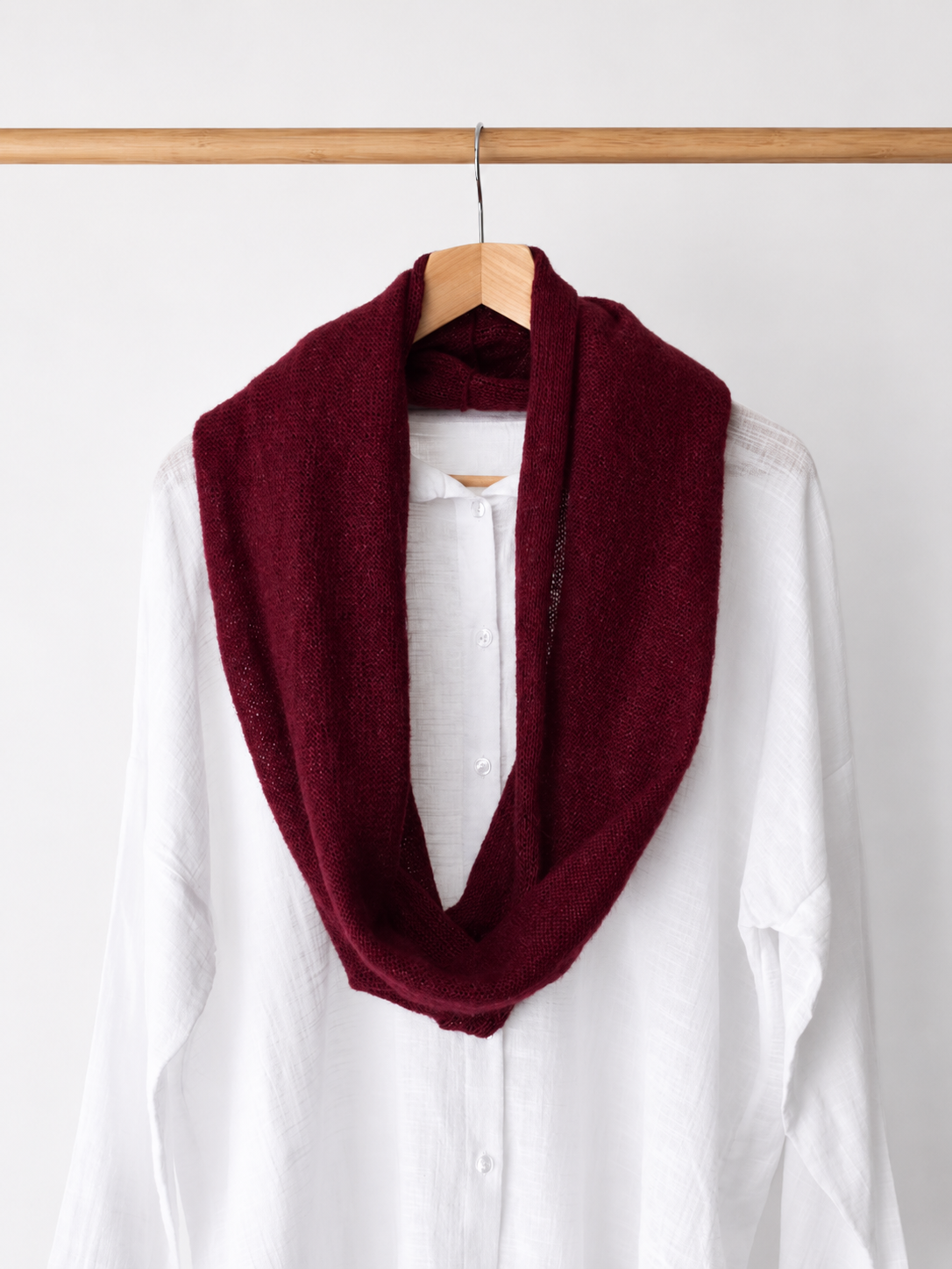 Burgundy loop scarf worn in a longer draped style.
