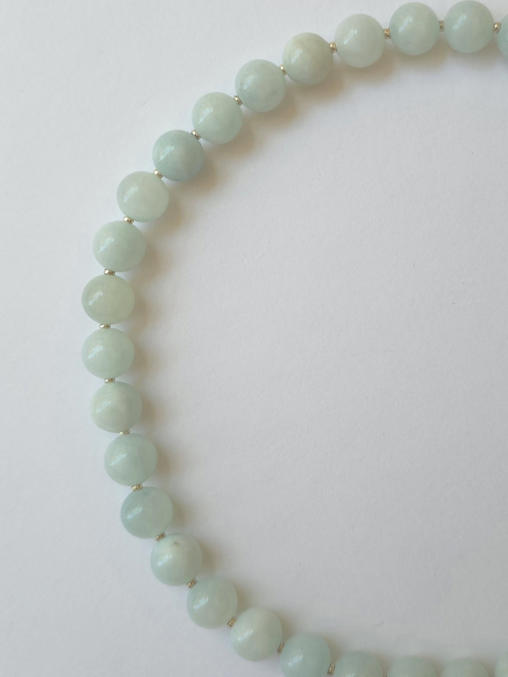 Close-up of pale green jadeite beads with silver Japanese seed bead spacers