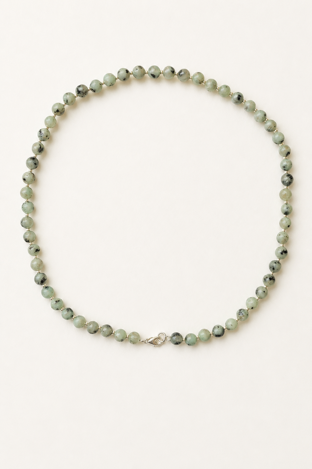 Kiwi jasper necklace with pale green 6mm beads, silver accents and lobster clasp on a warm ivory background