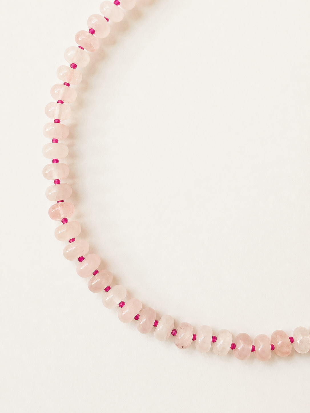 Detailed view of 5x8mm rose quartz rondelles separated by faceted fuchsia glass beads