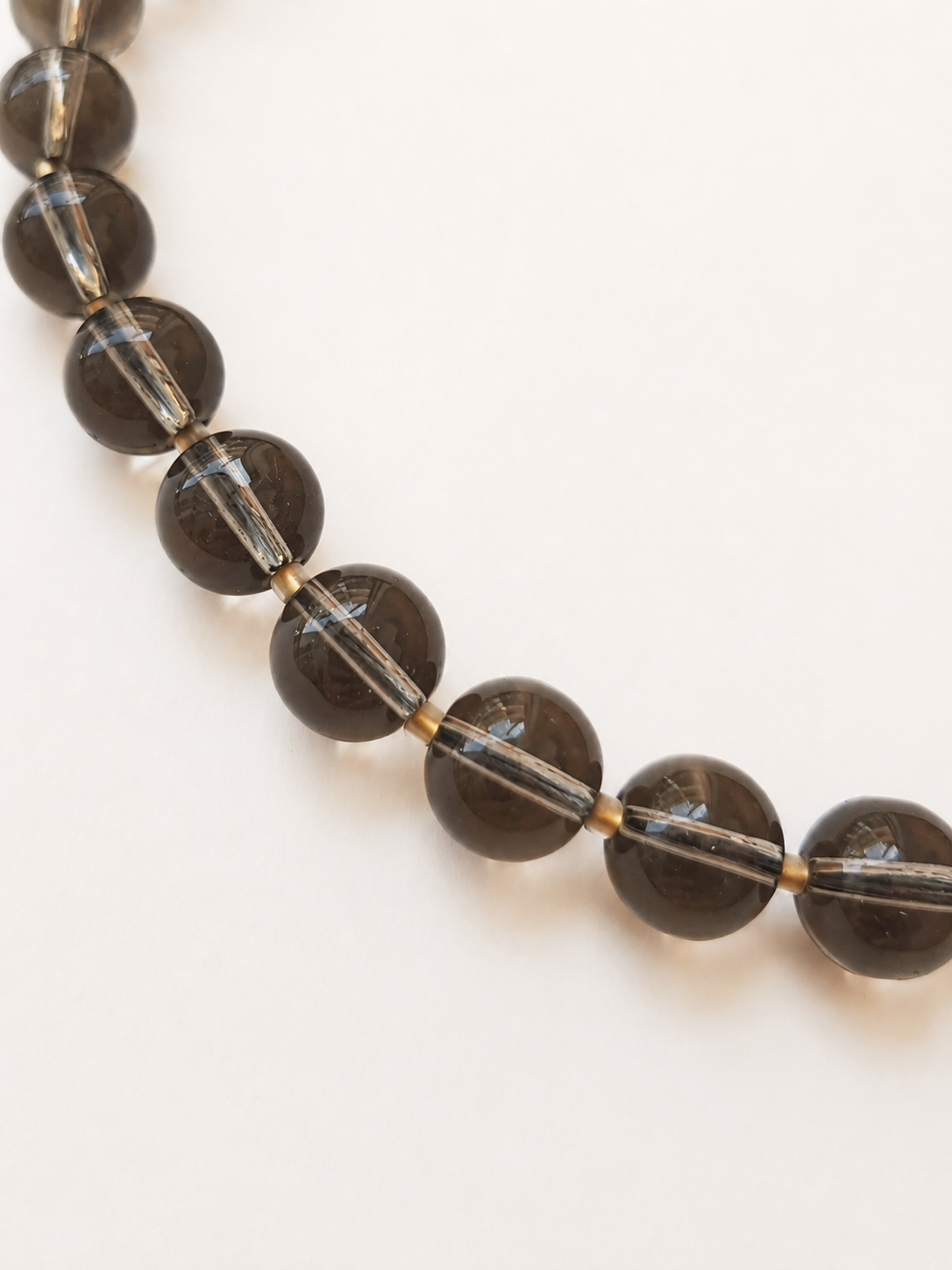 Close-up of polished smoky quartz beads with Japanese Toho gold-lined frosted crystal spacers