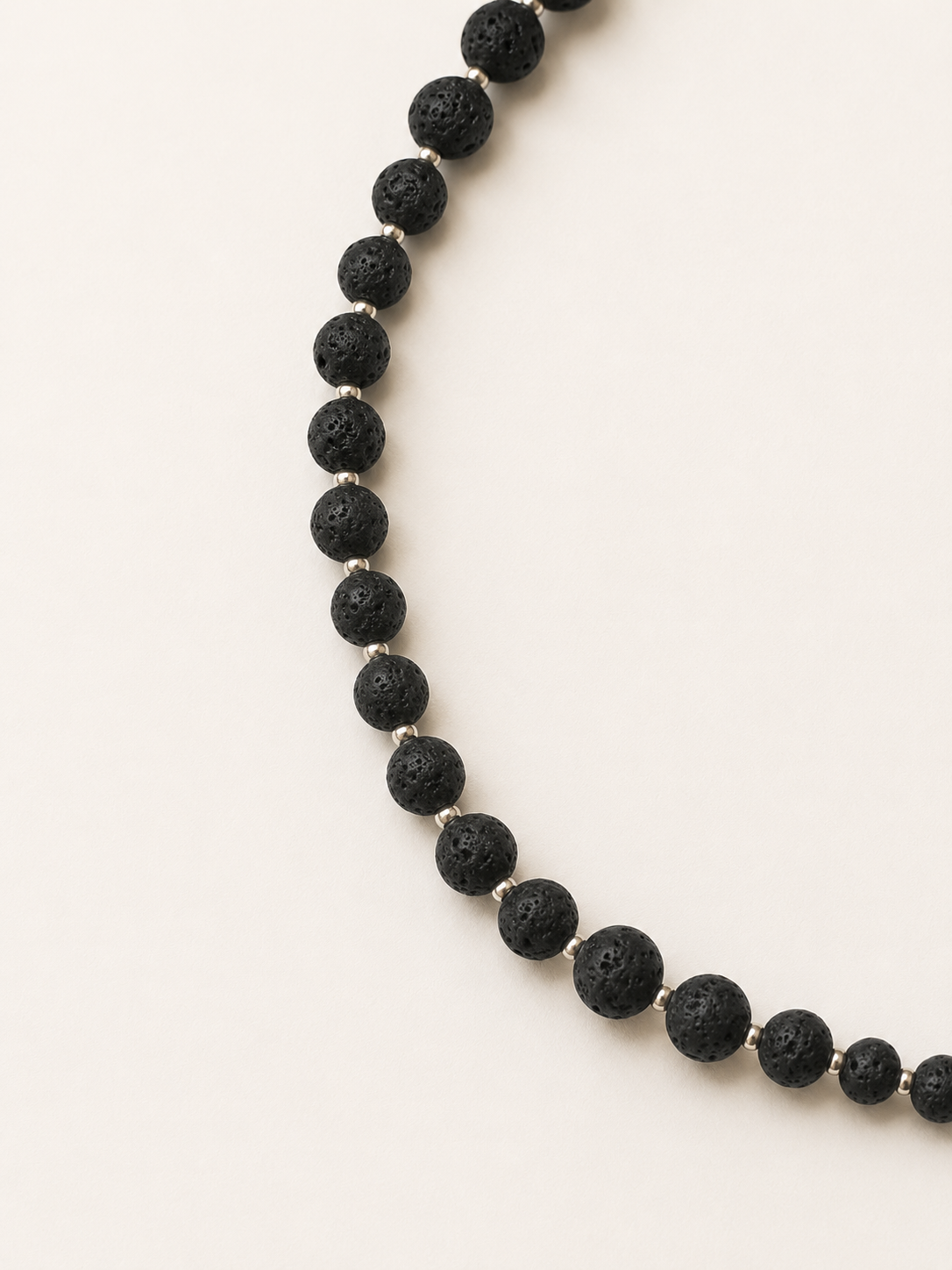Close-up of porous black lava beads with silver Miyuki spacers