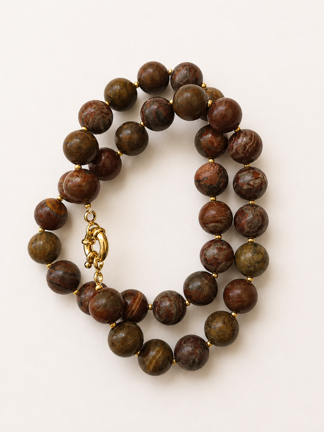 Coiled agate necklace showing varied natural bead patterns and a golden spring ring clasp