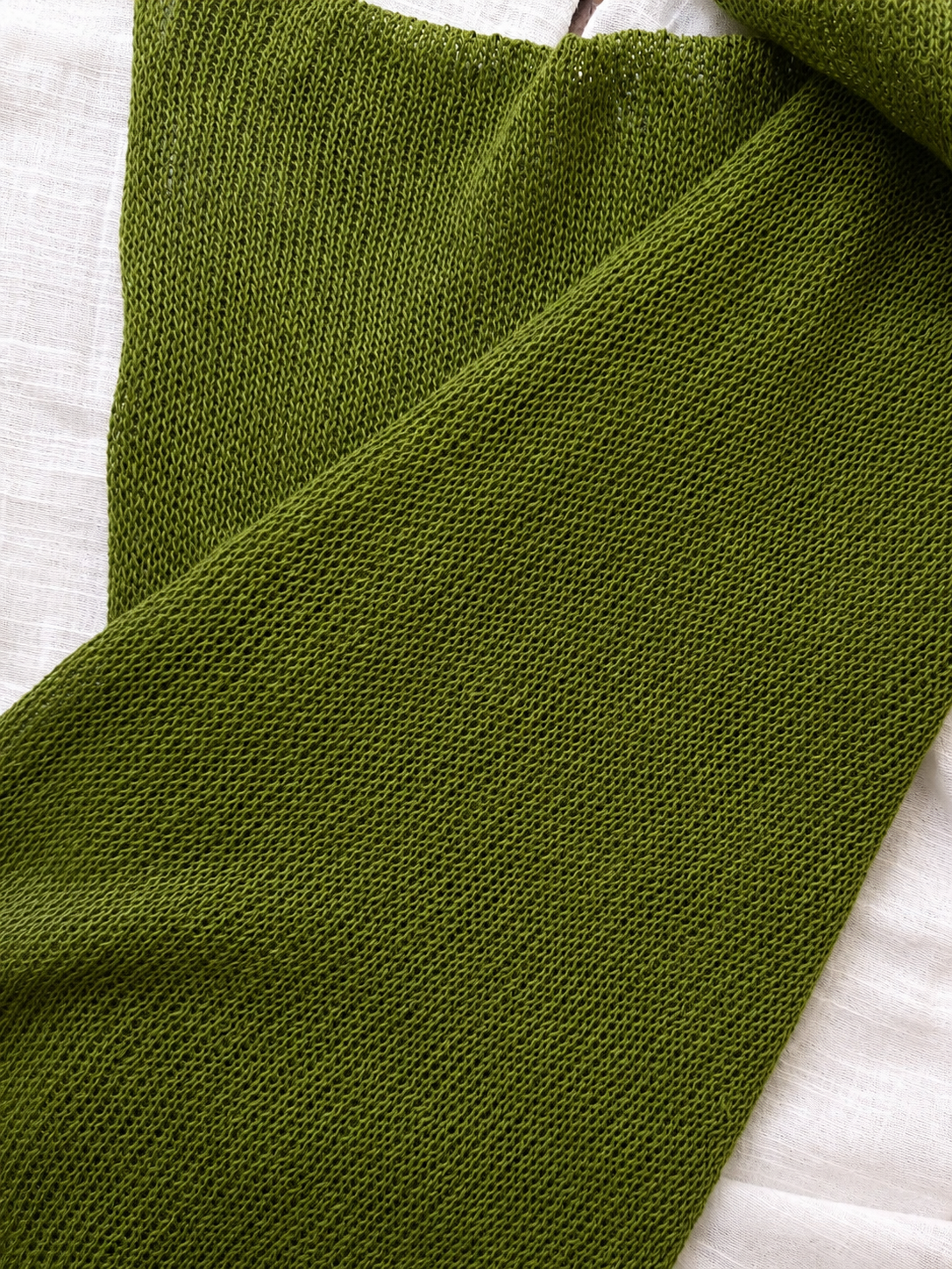 Close-up of the breathable knit texture of the Olive Green linen scarf.