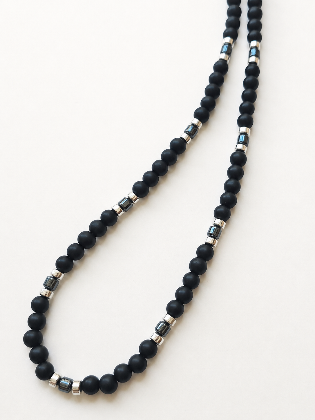Long matte black synthetic shungite necklace showing repeating gunmetal and silver accents