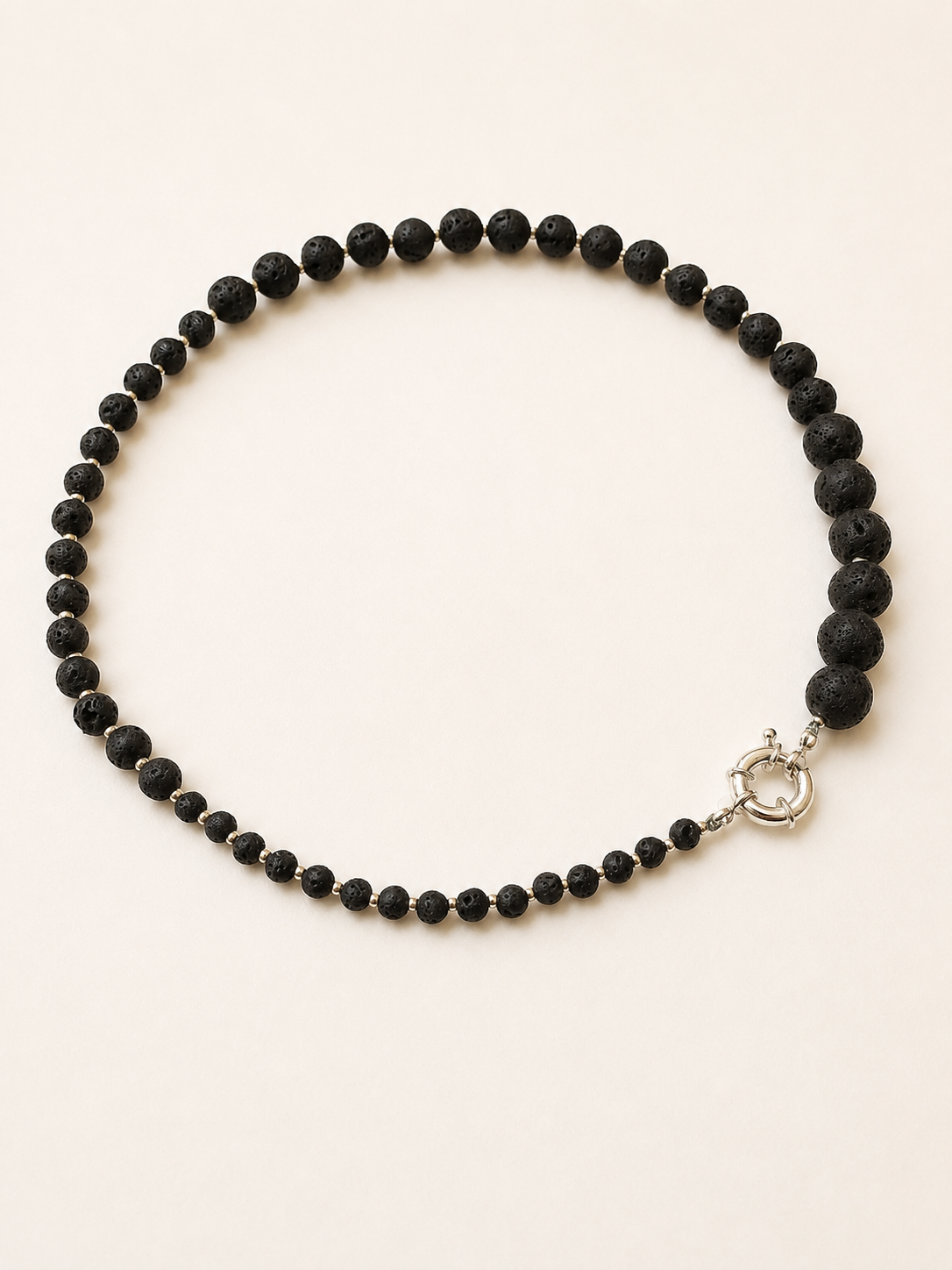 Black lava necklace arranged to show the transition from small to large stone beads