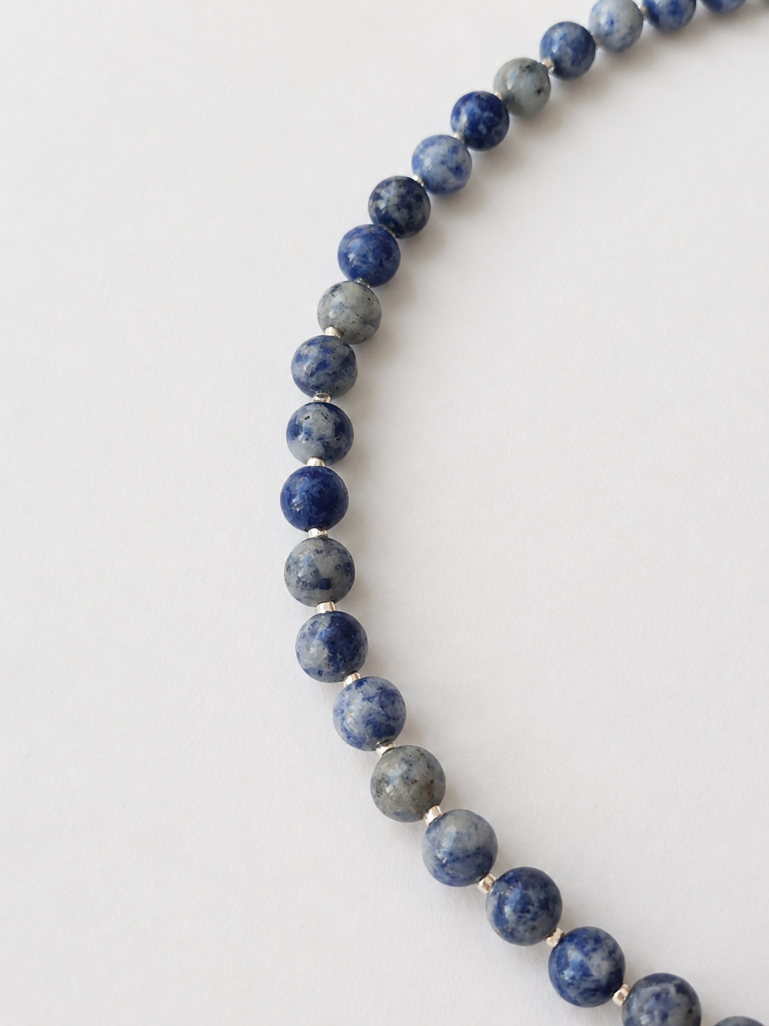Detailed view of natural marbled patterns across polished sodalite gemstone beads